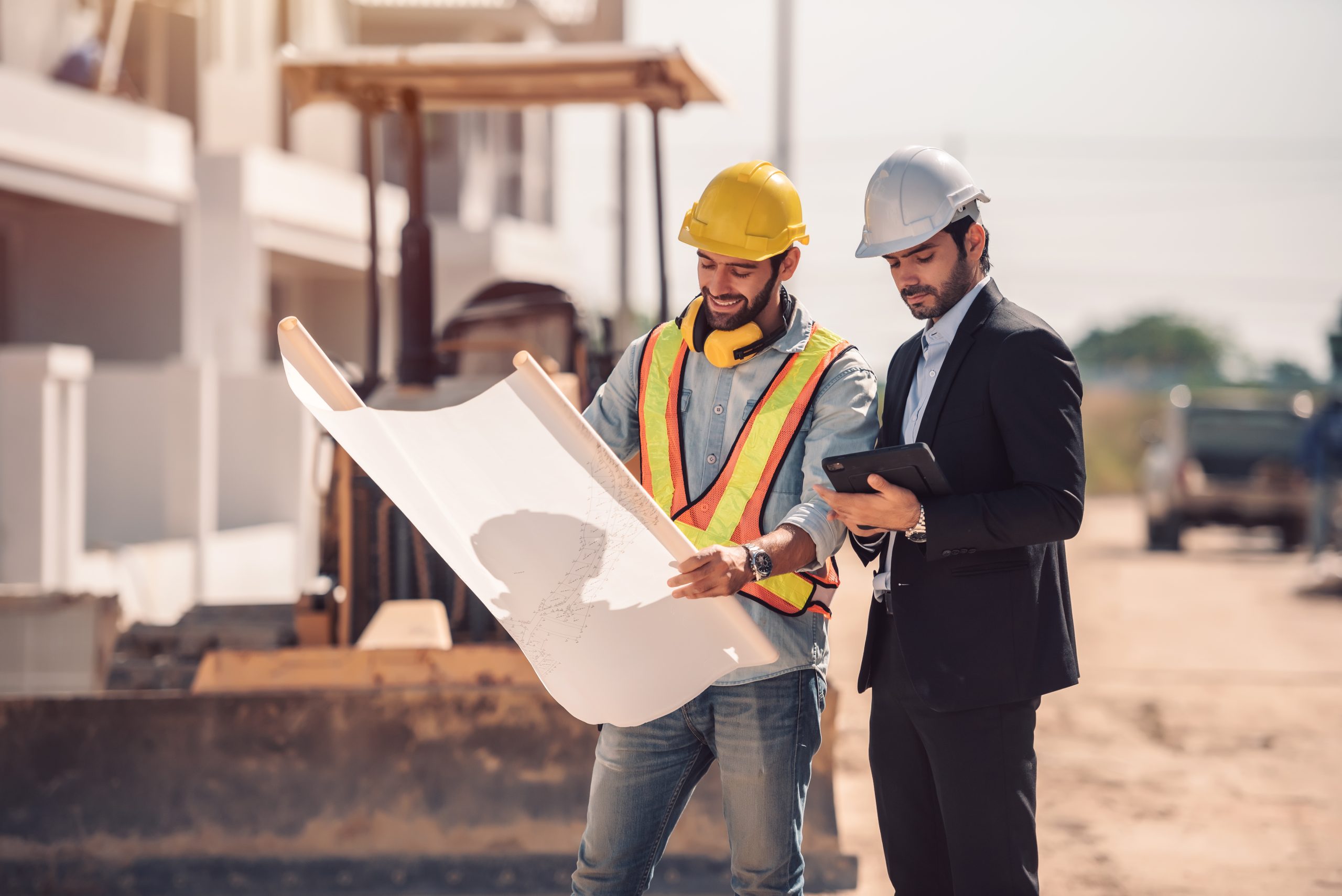 ingeniero civil y gerente de trabajadores de la construccion con tableta digital y planos hablando y planeando sobre el sitio de construccion concepto de trabajo en equ